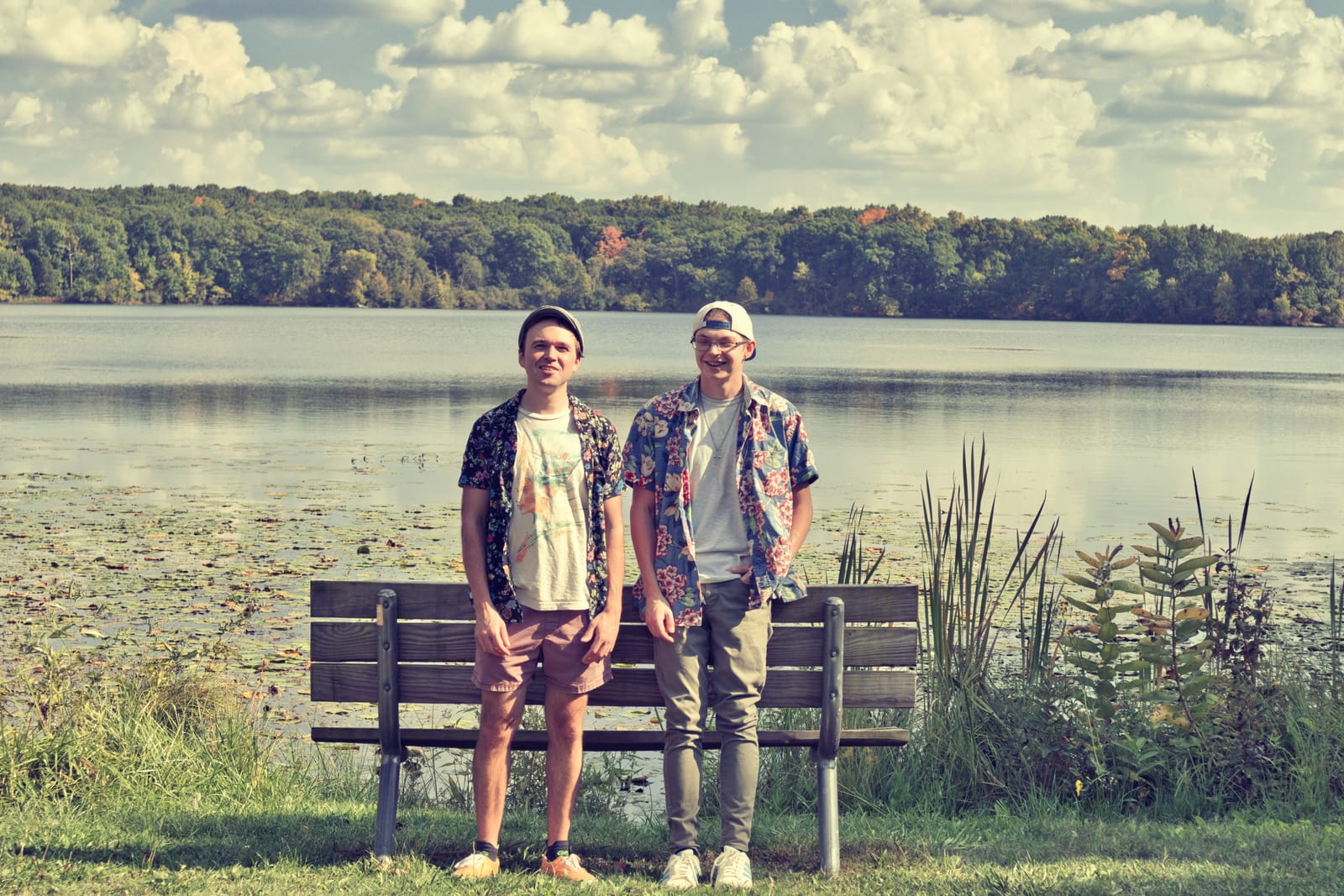 Stephen Michael and Jake Long standing by a lakeside bench