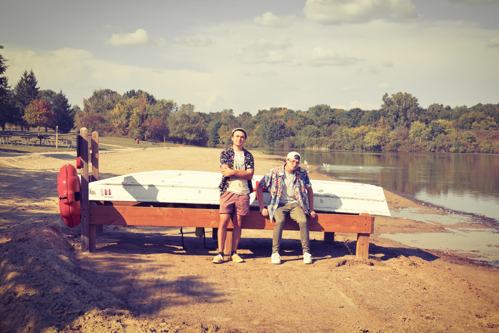 Stephen Michael and Jake Long sitting beside a boat at the lake