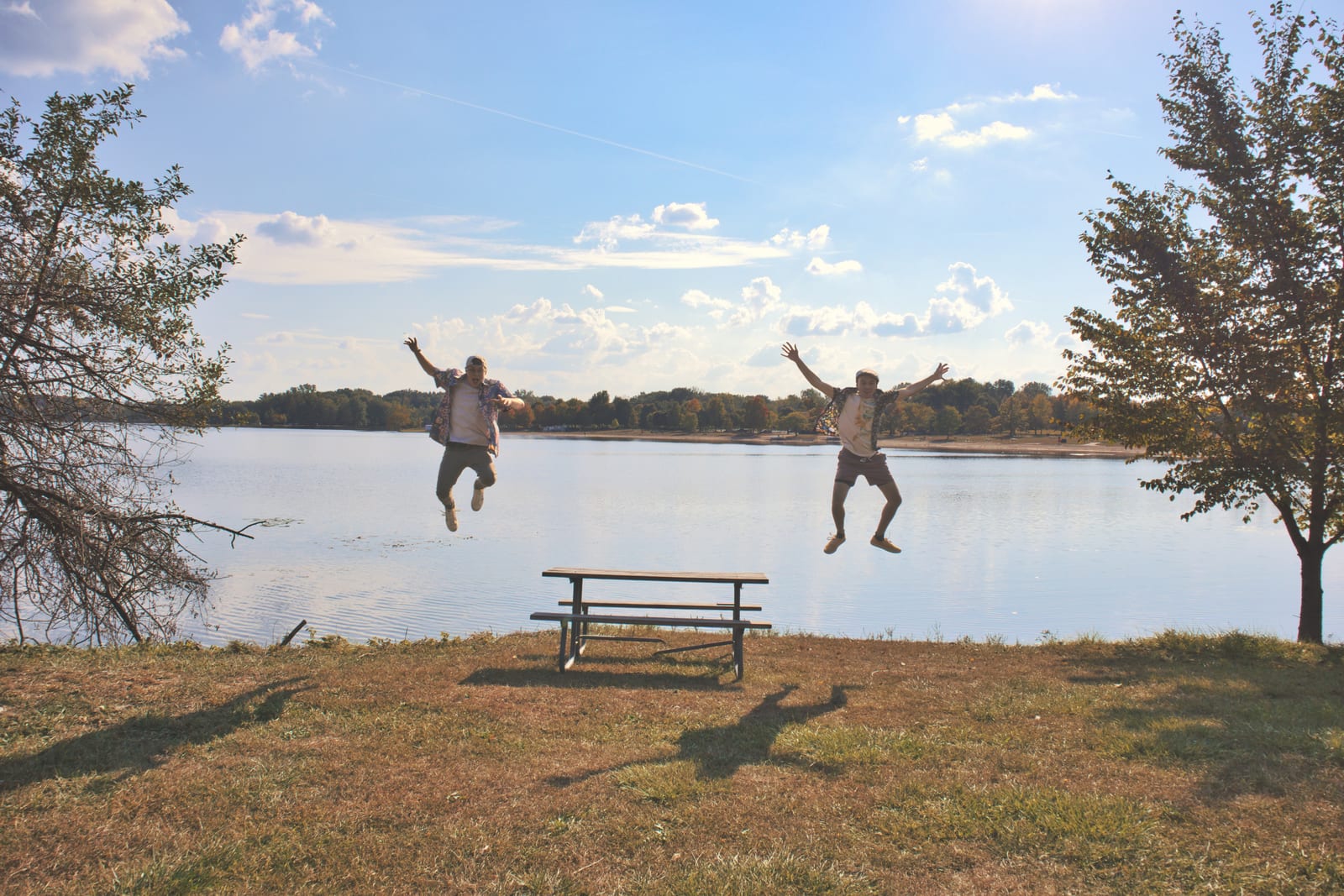 Stephen Michael and Jake Long leaping beside the lake