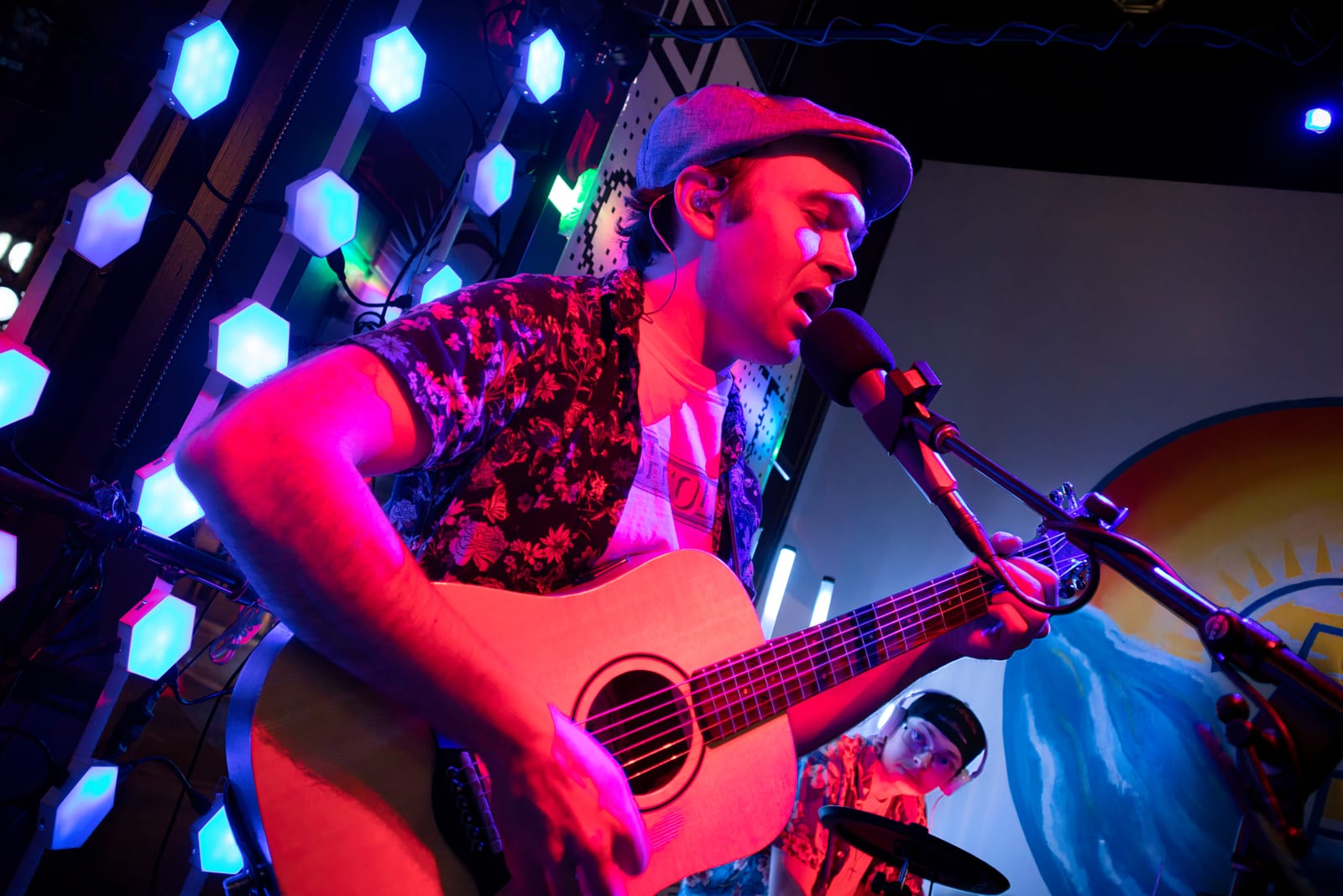 Stephen Michael singing and playing acoustic guitar during a COAST show